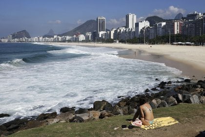 Una mujer toma sol en un morro luego del cierre de playas en Río de Janeiro - REUTERS/Ricardo Moraes