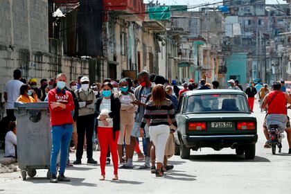 Personas con tapabocas hacen fila el 2 de febrero de 2021 para comprar alimentos en un mercado de La Habana (Cuba). EFE/ Ernesto Mastrascusa