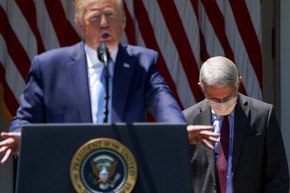 El director del Instituto Nacional de Alergia y Enfermedades Infecciosas, Anthony Fauci, escucha al presidente Donald Trump en la Casa Blanca (Reuters)