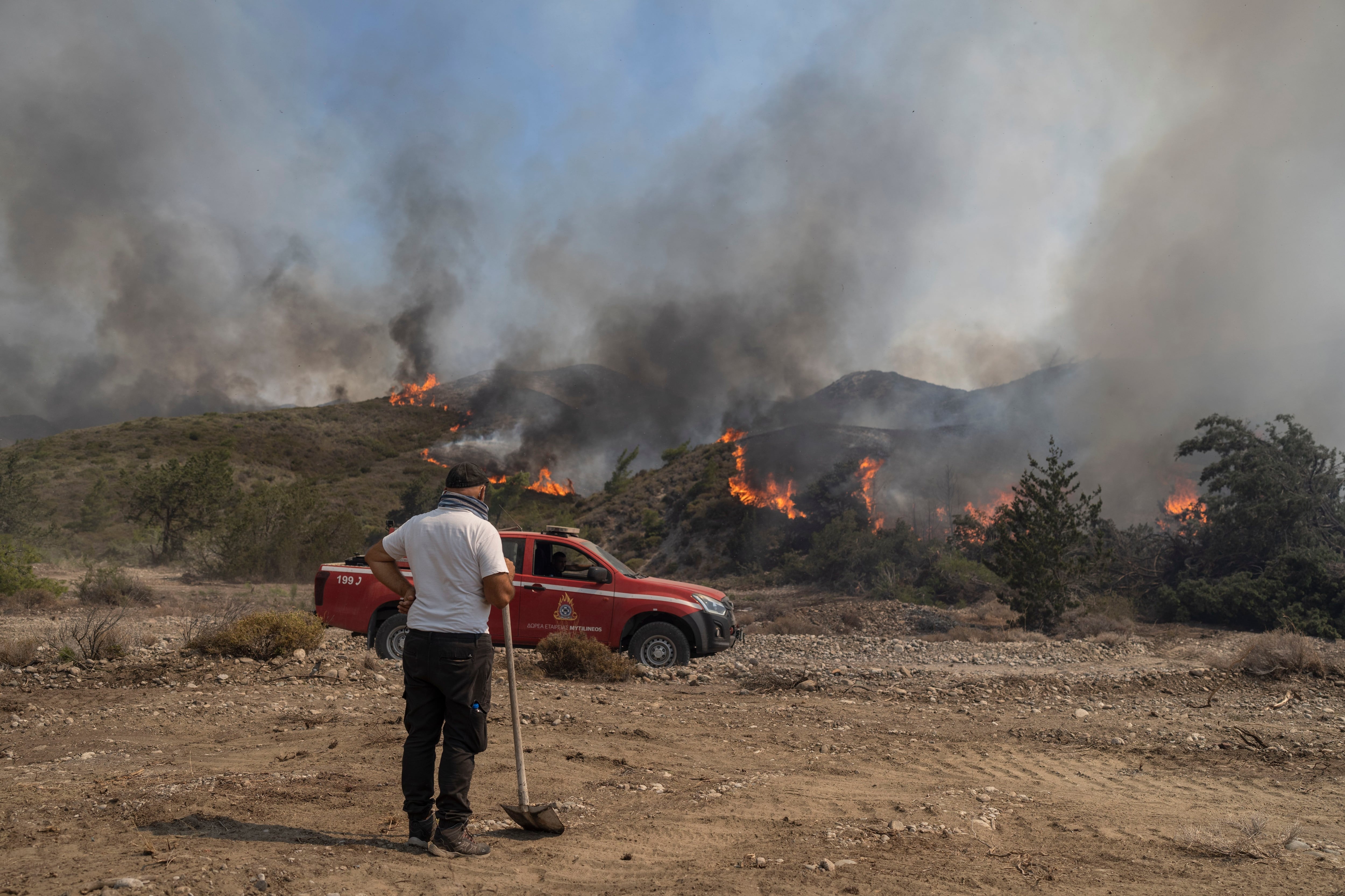 Un hombre observa las llamas que queman un monte en la localidad de Vati, en la isla de Rodas. (AP Foto/Petros Giannakouris)