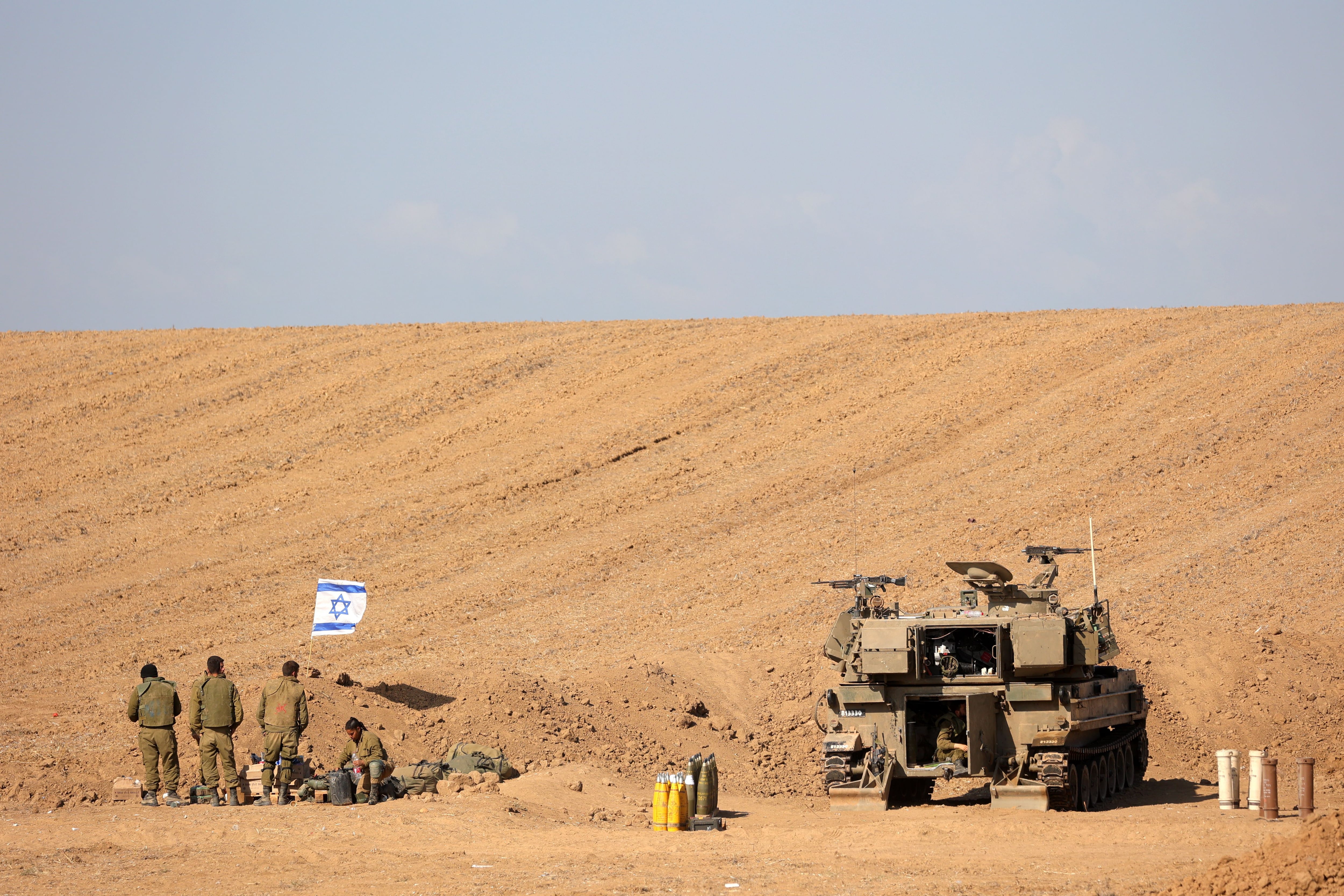 Un grupo de soldados israelíes cerca de un tanque en una zona a lo largo de la frontera con Gaza, en el sur de Israel, el 15 de octubre de 2023. EFE/EPA/ABIR SULTAN


