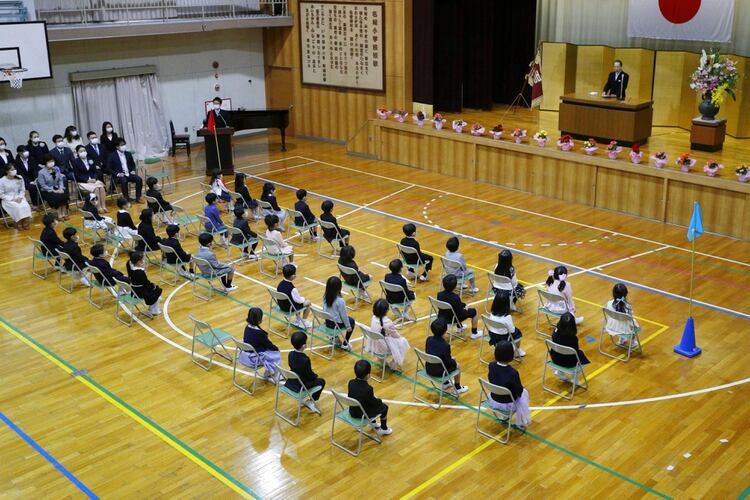 Una ceremonia en una escuela inicial de Japón, manteniendo la distancia social (Kyodo/via REUTERS)