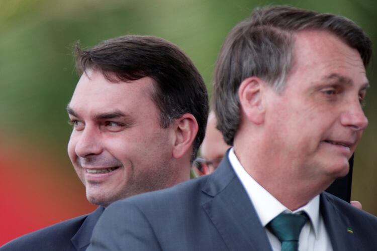 El senador Flavio Bolsonaro sonriente detrás del presidente Jair Bolsonaro (REUTERS/Ueslei Marcelino)