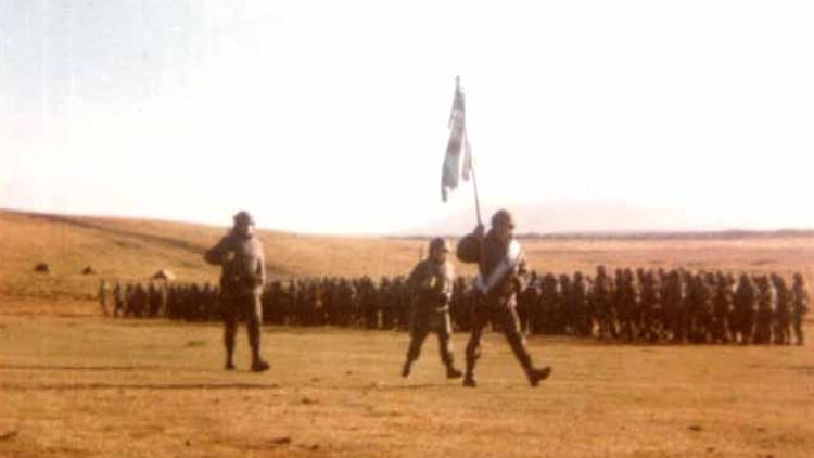 La bandera del Regimiento 8 desfila durante el juramento que se realizó en las Islas, en 1982. Foto: Gentileza capitán retirado Marcelo Giglio. 