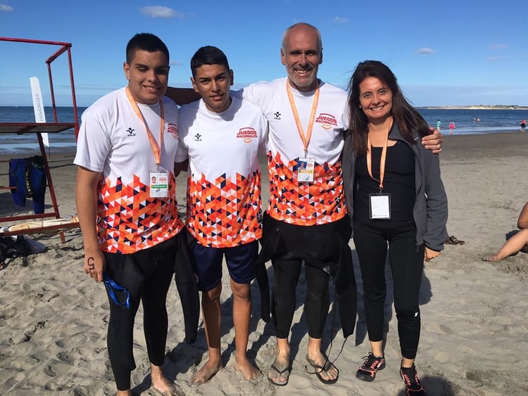Nico, Yonatan, Juan y la médica de la delegación tucumana posan con el Golfo Nuevo de fondo