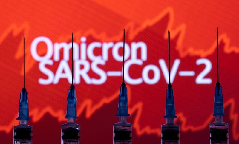 FILE PHOTO: Syringes with needles are seen in front of a displayed stock graph and words "Omicron SARS-CoV-2" in this illustration taken, November 27, 2021. REUTERS/Dado Ruvic/Illustration