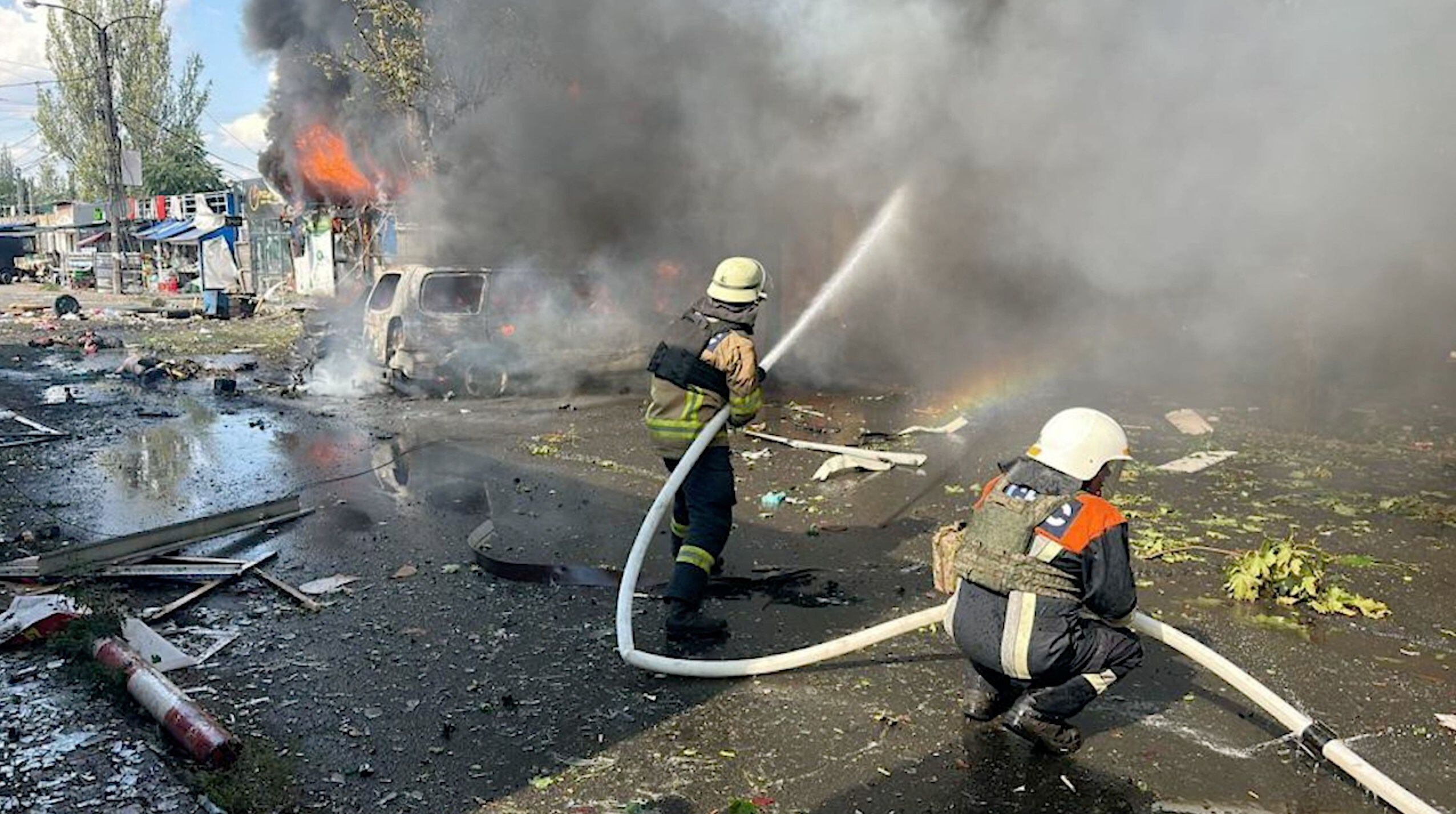 Los bomberos intentando apagar las llamas tras el bombardeo (REUTERS)