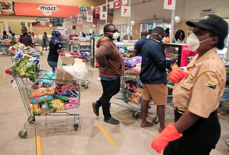 Gente hace cola para pagar los productos en un supermercado antes de un cierre nacional de 21 días llamado por el gobierno para limitar la propagación de la enfermedad por coronavirus en Harare, la capital de Zimbabwe (Reuters)
