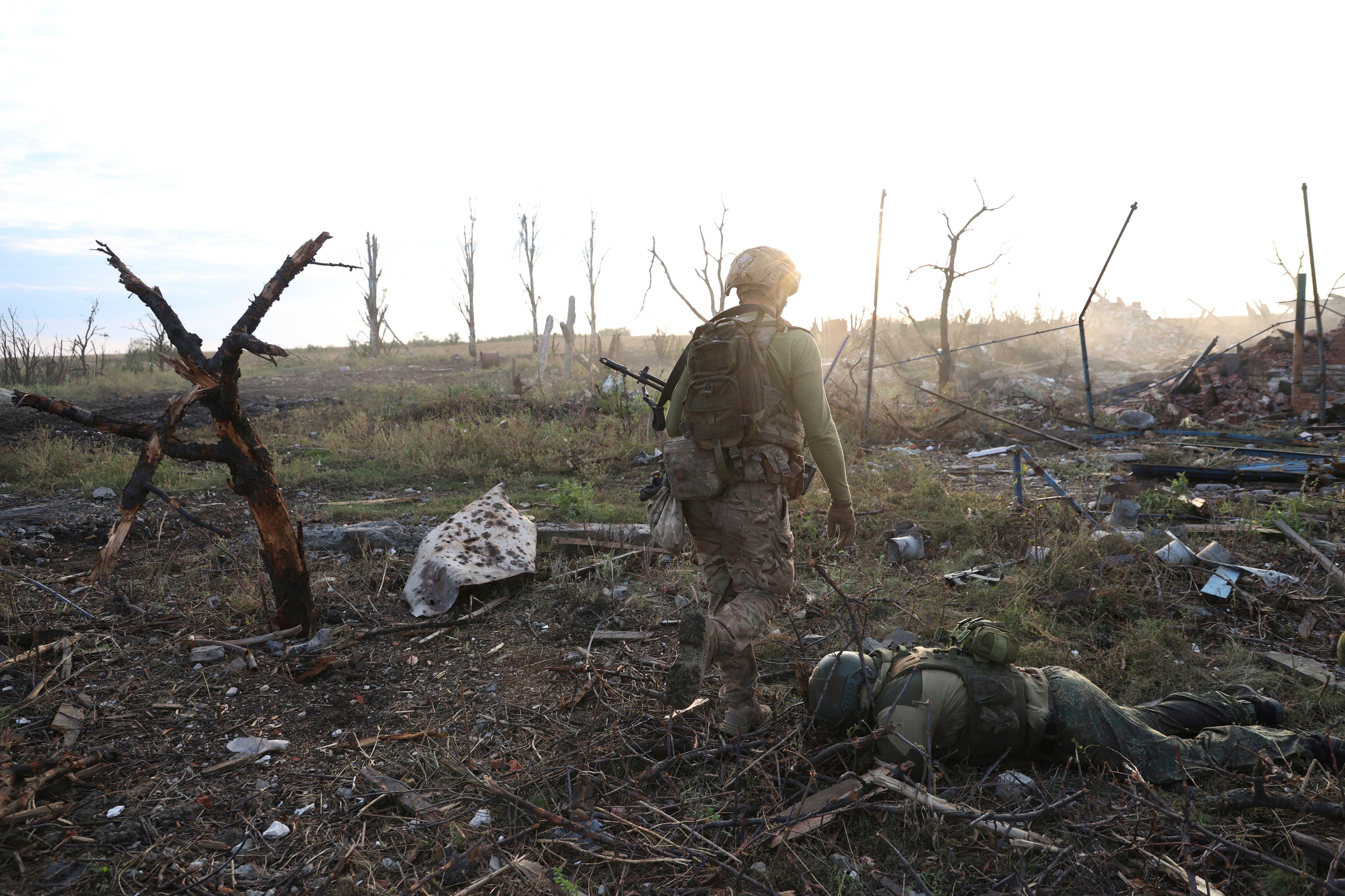 Un comandante de una unidad de la 3ra Brigada de Asalto que utiliza el nombre de Fedia pasa junto al cuerpo de un soldado ruso muerto en Andriivka, en la región de Donetsk, Ucrania (AP Foto/Alex Babenko)