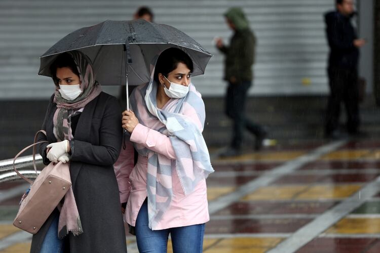 Dos mujeres se protegen en Teherán, Irán (REUTERS)