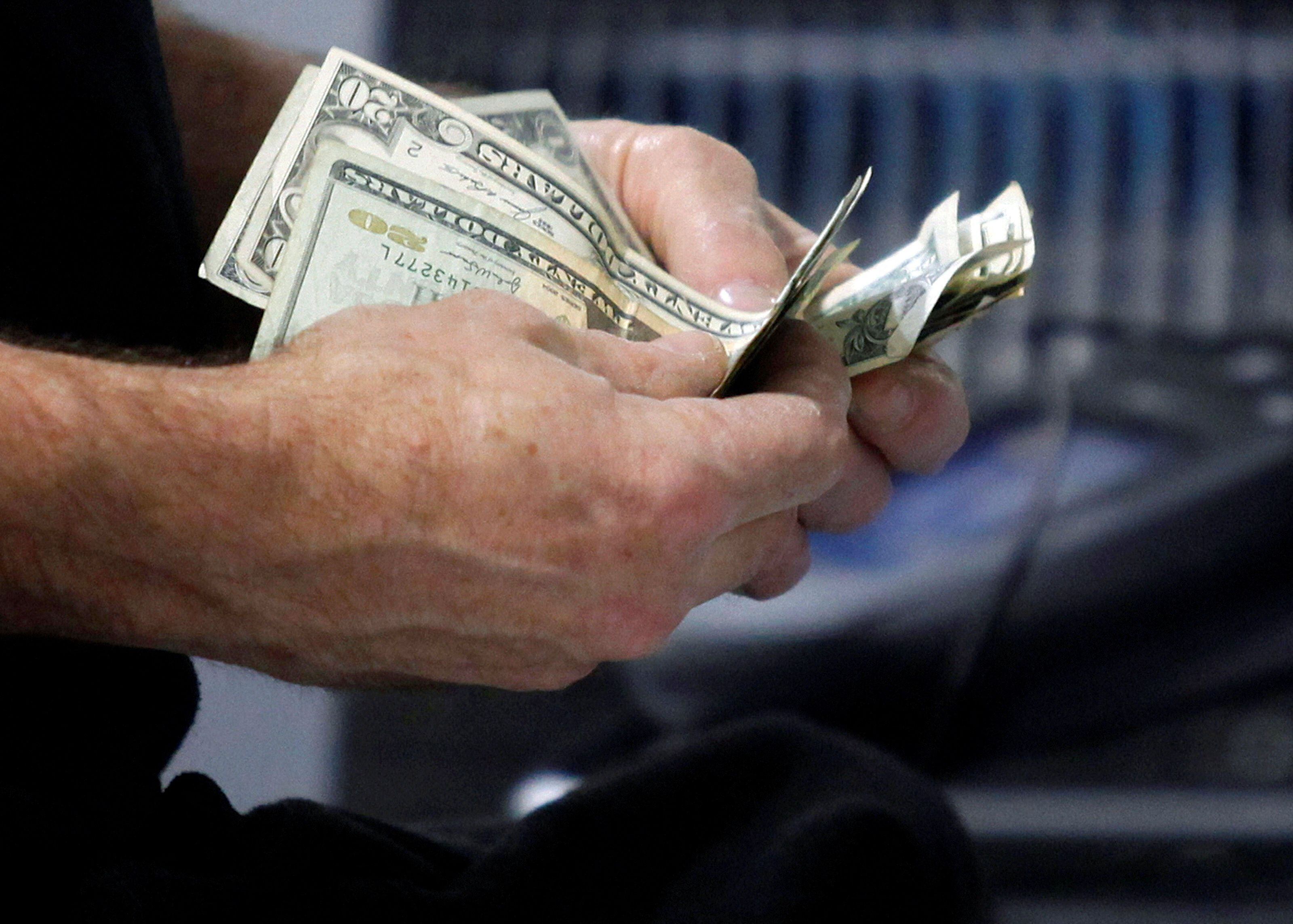 Un cliente cuenta su dinero (REUTERS/Jessica Rinaldi)