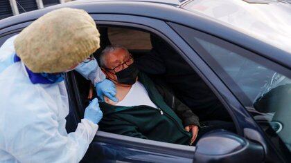 Un anciano recibe la vacuna contra el coronavirus desde un auto en Ronda, España. 11 febrero 2021. REUTERS/Jon Nazca