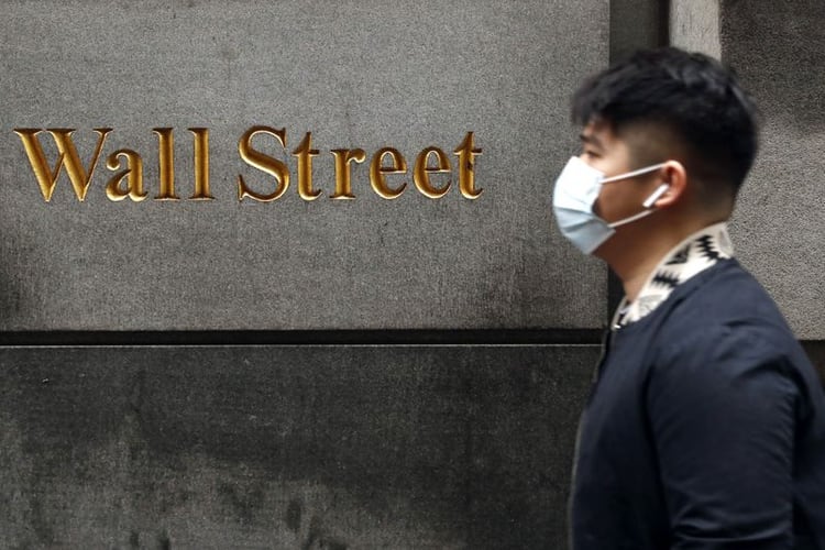 Un hombre usando una masacarilla quirúrgica camina Wall Street durante el brote de coronavirus en Nueva York. Estados Unidos 13 de marz 2020. REUTERS/Lucas Jackson