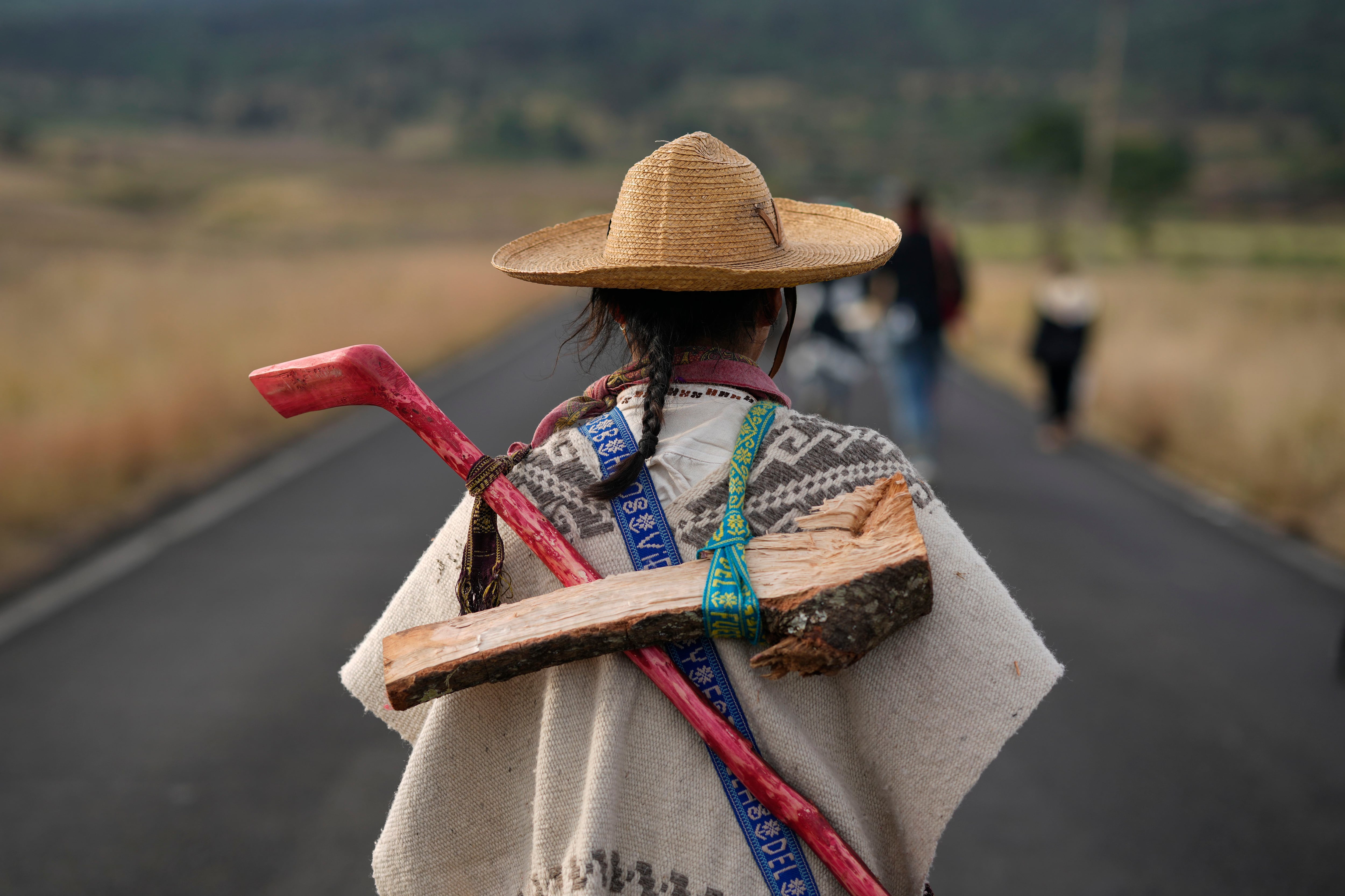 Imagen de referencia. Un indígena purépecha lleva madera y un palo mientras camina con un grupo desde Erongarícuaro, donde los residentes mantuvieron viva una llama durante un año, hasta Ocumicho en el estado de Michoacán, México, el martes 30 de enero de 2024. (AP Foto/Eduardo Verdugo)