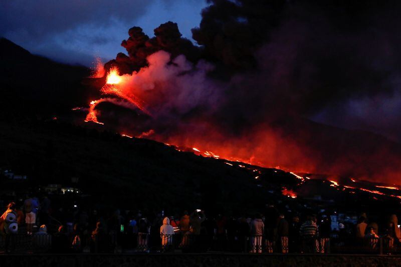 Gente observa cómo el volcán Cumbre Vieja arroja lava y humo mientras sigue en erupción, visto desde Tajuya, en la isla canaria de La Palma, España. 22 de octubre de 2021. REUTERS/Susana Vera