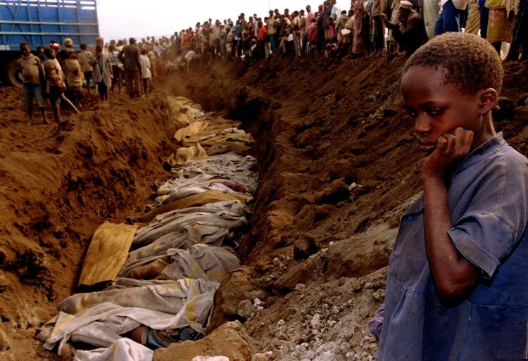 Una niña refugiada contempla una fosa común donde fueron enterrados decenas de cuerpos el 20 de julio de 1994 (Reuters)