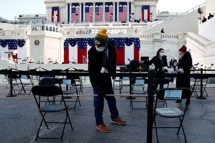 Un hombre mide la distancia entre los asientos en medio de las medidas de seguridad COVID-19, en el frente oeste del Capitolio antes de la inauguración presidencial de Joe Biden en Washington, EE. UU., el 20 de enero de 2021. REUTERS / Jim Bourg