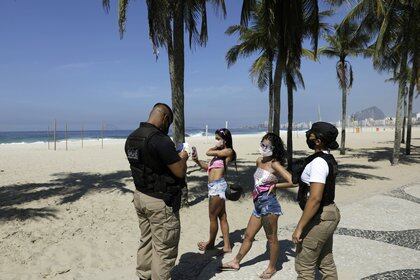 Oficiales informan a personas que no pueden estar en las playas (REUTERS/Ricardo Moraes)
