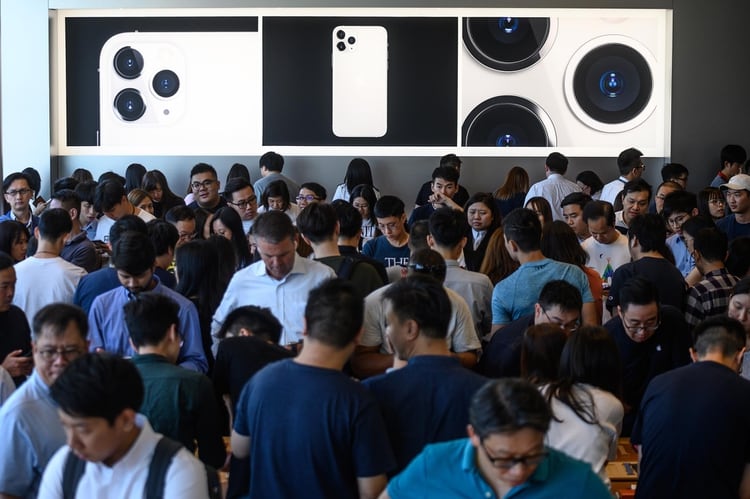 Clientes probando el teléfono en una tienda de Apple ubicada en Hong Kong (Photo by Philip FONG / AFP)