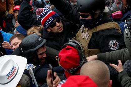 Un asaltante con prendas militares luce un parche en el hombro con el símbolo de Q (Reuters)