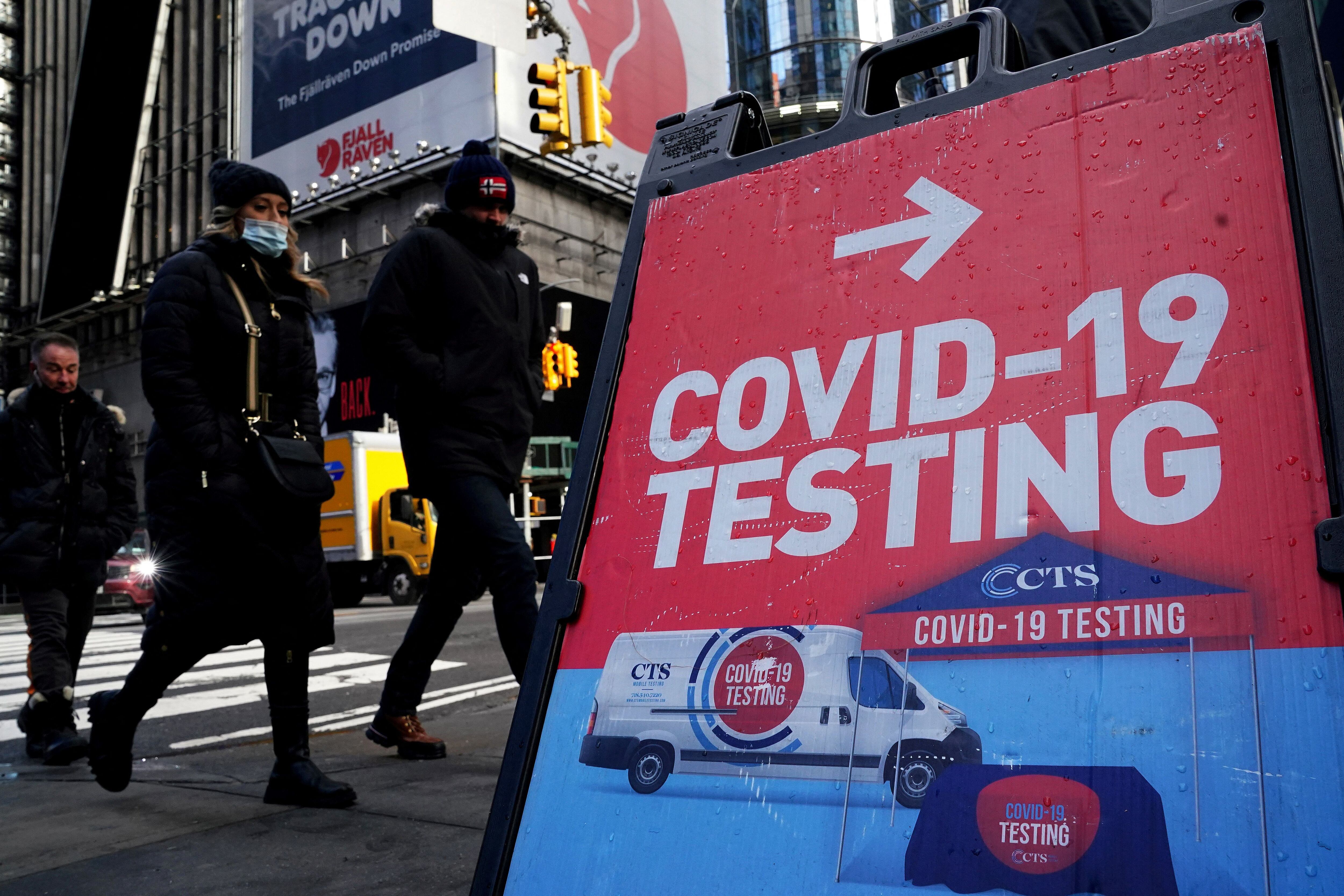 Foto de archivo: Personas pasan por delante de un cartel de pruebas de COVID-19 en la ciudad de Nueva York, Estados Unidos, el 20 de enero de 2022 (REUTERS/Carlo Allegri)