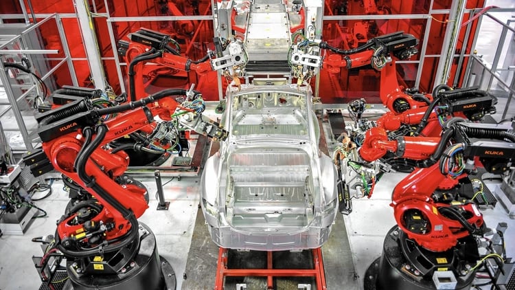 Unos robots ensamblan las piezas de un auto eléctrico Tesla