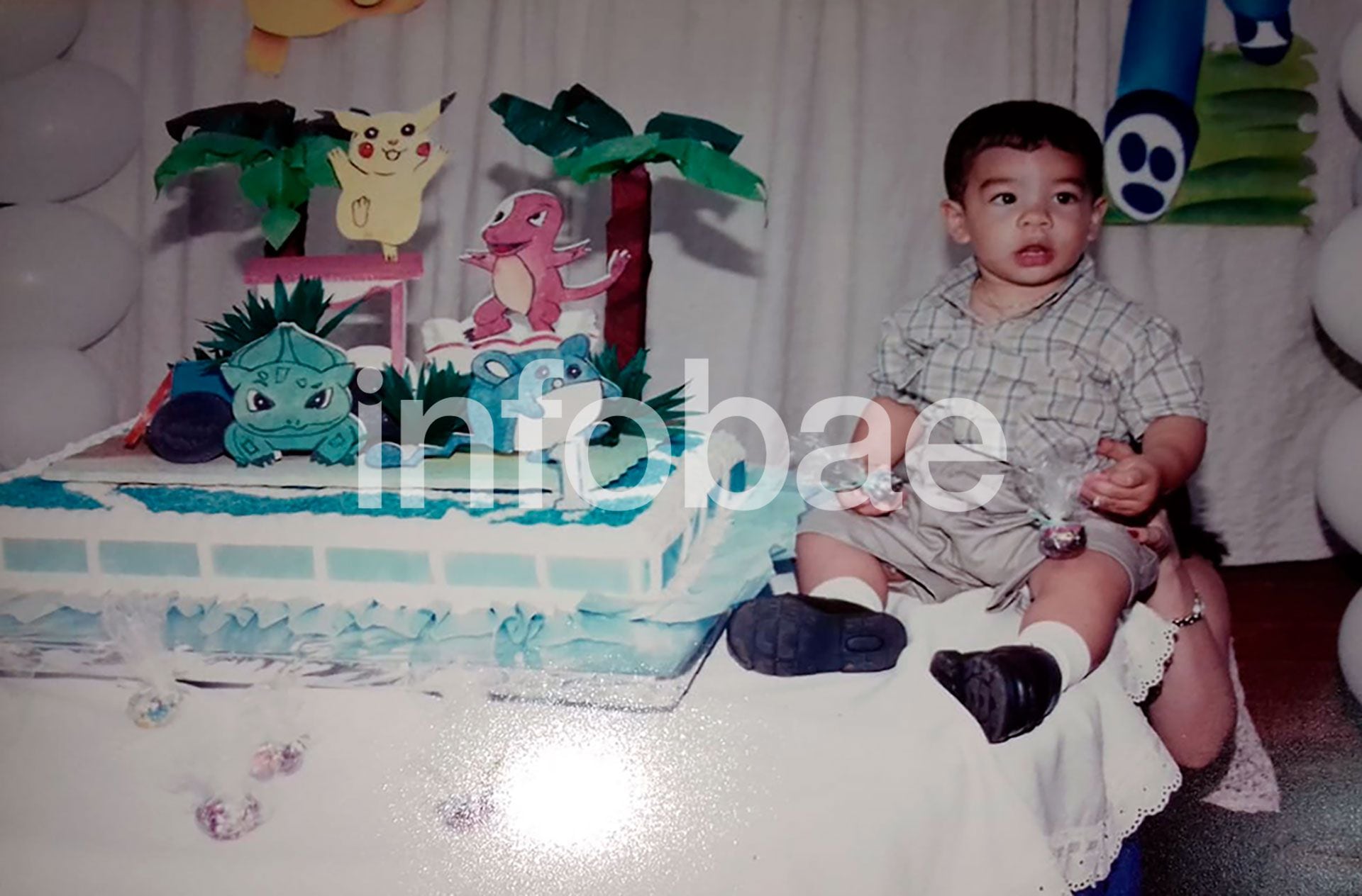 Fernando Báez Sosa durante el festejo de su primer cumpleaños. Por debajo de la mesa, lo sostiene su mamá. La torta tenía la temática de la serie Pokémon (Foto / Gentileza GBS y JR). 