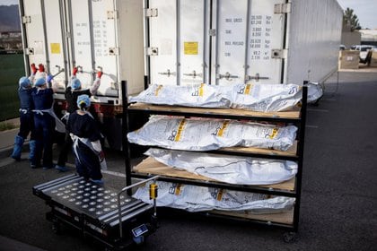 FILE PHOTO: El Paso County Medical Examiner's Office staff lock-up the mobile morgues before moving bodies that are in bags labeled "Covid" from refrigerated trailers into the morgue office amid the coronavirus disease (COVID-19) outbreak, in El Paso, Texas, U.S. November 23, 2020. REUTERS/Ivan Pierre Aguirre/File Photo