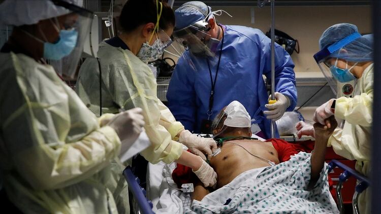 El Dr. Anthony Leno, Director de Medicina de Emergencia, centro superior, asiste a las enfermeras mientras reciben a un paciente de un hogar de ancianos que muestra síntomas de COVID-19 (AP/John Minchillo)