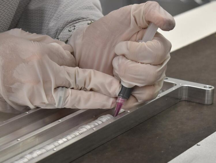 Un técnico inserta las cápsulas de Celestis rellenas con las cenizas de 152 personas diferentes en el satélite Orbital Test Bed (Foto: Archivo)
