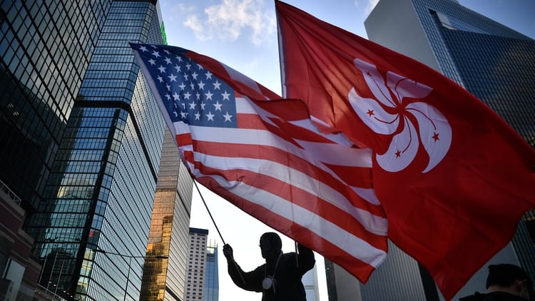 Un manifestante ondea juntas las banderas de Hong Kong y Estados Unidos, que se encuentra en medio de su propio conflicto, comercial y geopolítica, con China (Anthony WALLACE / AFP)