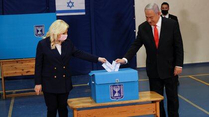 Israeli Prime Minister Benjamin Netanyahu and his wife Sara cast their ballots at a polling station as Israelis vote in a general election, in Jerusalem March 23, 2021. REUTERS/Ronen Zvulun/Pool