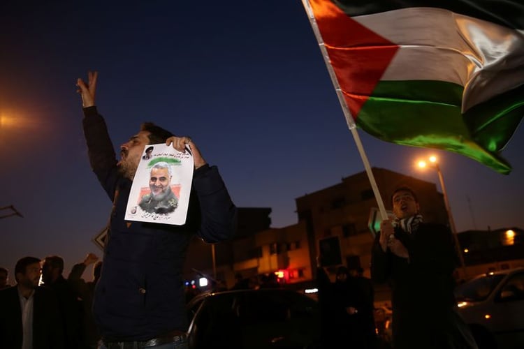 Un hombre sostiene una foto del difunto mayor general iraní Qassem Soleimani, mientras la gente celebra en la calle después de que Irán lanzó misiles contra las fuerzas lideradas por Estados Unidos en Irak, en Teherán, Irán, 8 enero 2020. Nazanin Tabatabaee/WANA (West Asia News Agency) vía REUTERS