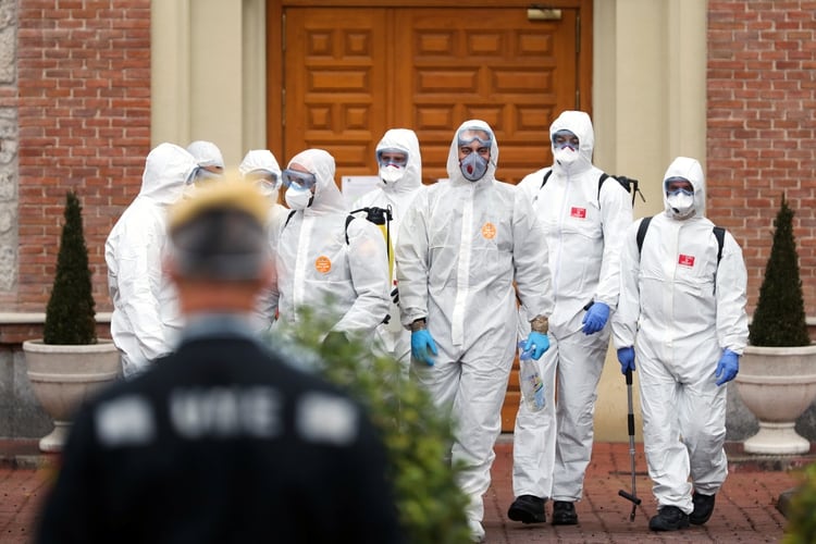 Miembros de la Unidad de Emergencia Militar (UME) abandonan un hogar para ancianos después de realizar procedimientos de desinfección durante el brote de coronavirus en Madrid (REUTERS / Susana Vera)