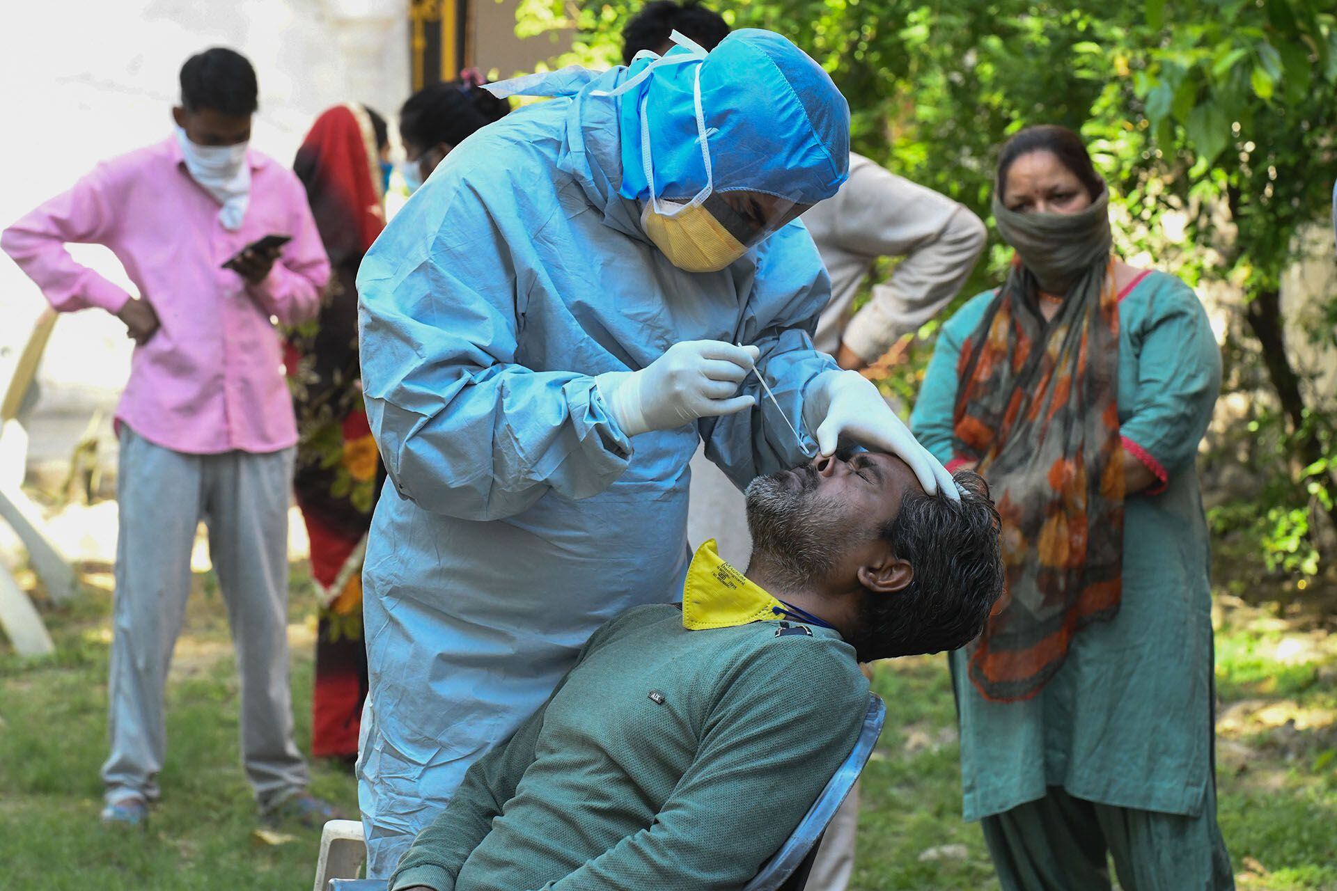 Un médico toma una muestra de un hombre para una prueba COVID-19 en Amritsar el 23 de abril de 2020. (Foto de NARINDER NANU / AFP)