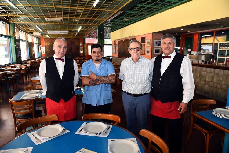 Hugo Banchero, nieto del fundador, junto a los mozos que tienen más de tres décadas de oficio en la emblemática pizzeria