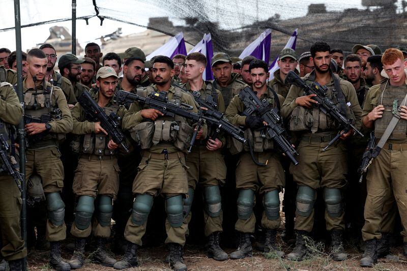 Soldados israelíes escuchan al ministro de Defensa de Israel, Yoav Gallant, mientras se reúne con ellos en un campo cerca de la frontera de Israel con la Franja de Gaza, en el sur de Israel. 19 de octubre de 2023. REUTERS/Ronen Zvulun