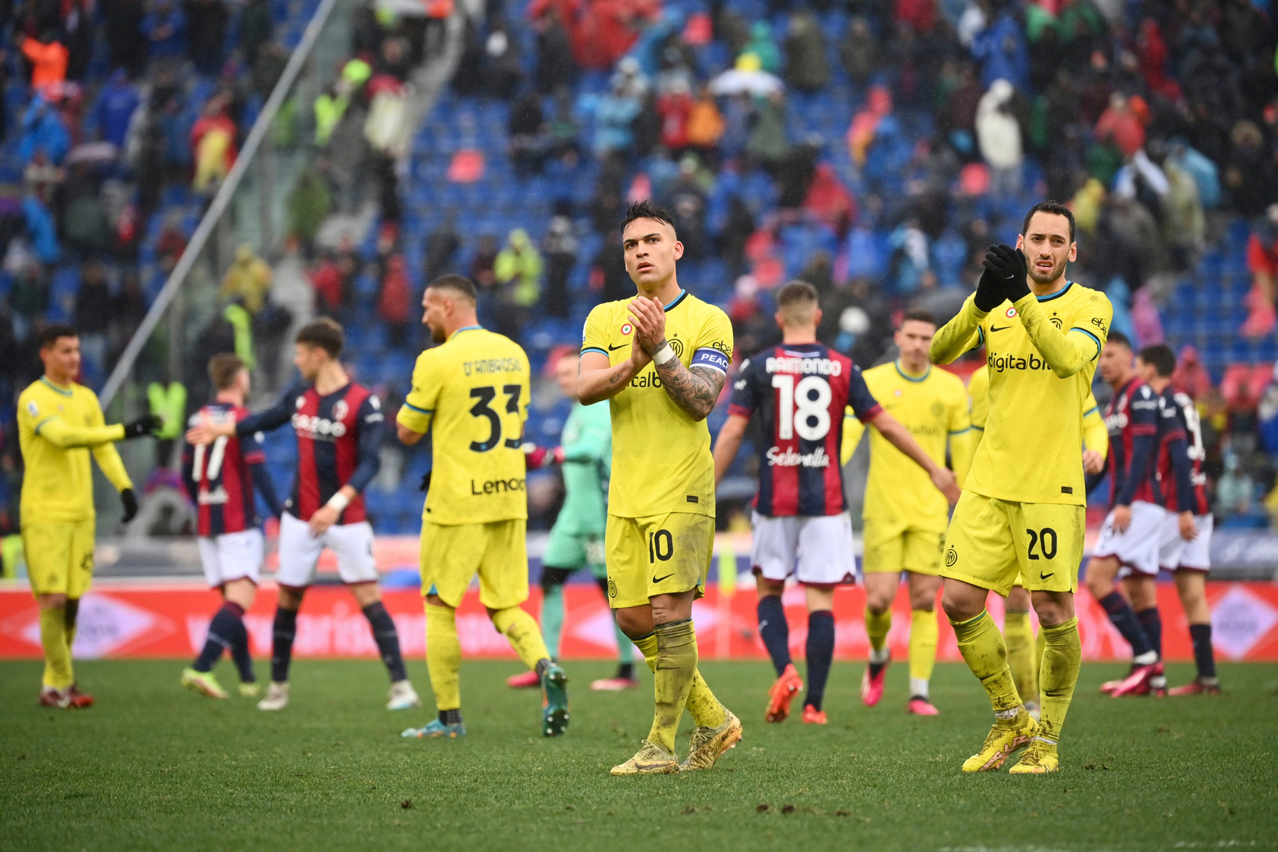 Lautaro Martínez (centro) y Hakan Calhanoglu (derecha) saludan a la afición tras la derrota 1-0 ante Bologna en la Serie A italiana, el domingo 26 de febrero de 2022. (Massimo Paolone/LaPresse vía AP)