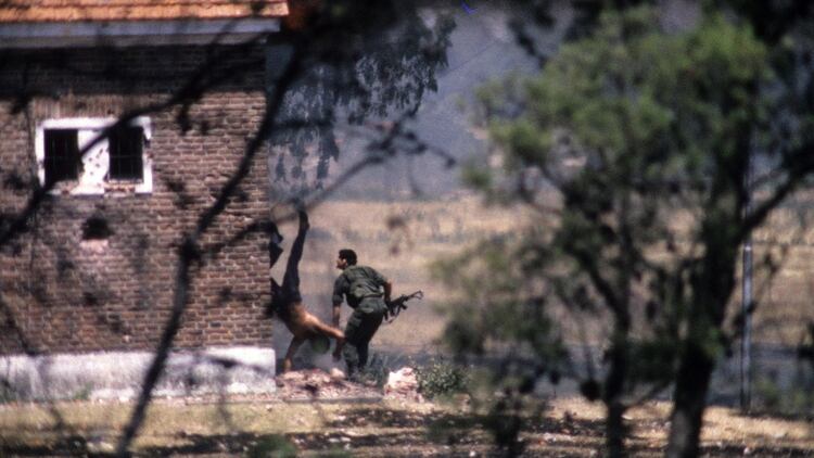 En la primera foto de la secuencia uno de los guerrilleros que copa el cuartel se arroja del edificio tomado (Eduardo Longoni)