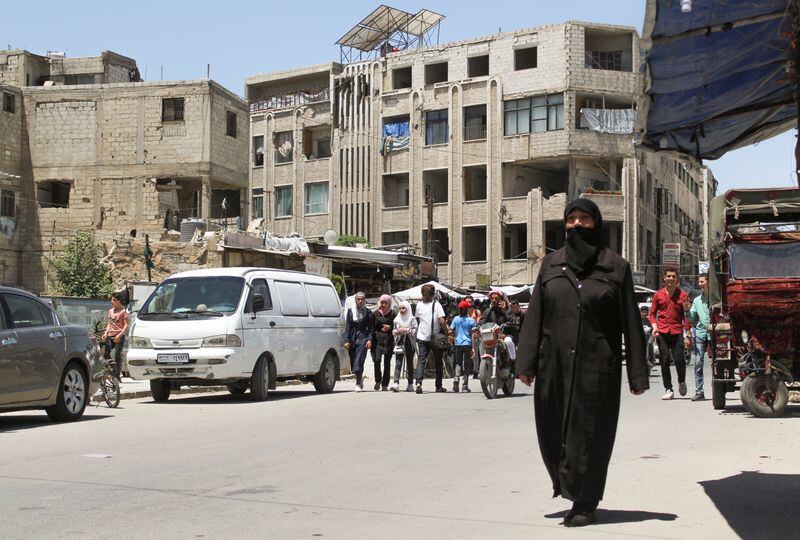 Varias personas caminan por una calle de Douma, Siria (REUTERS/Firas Makdesi)
