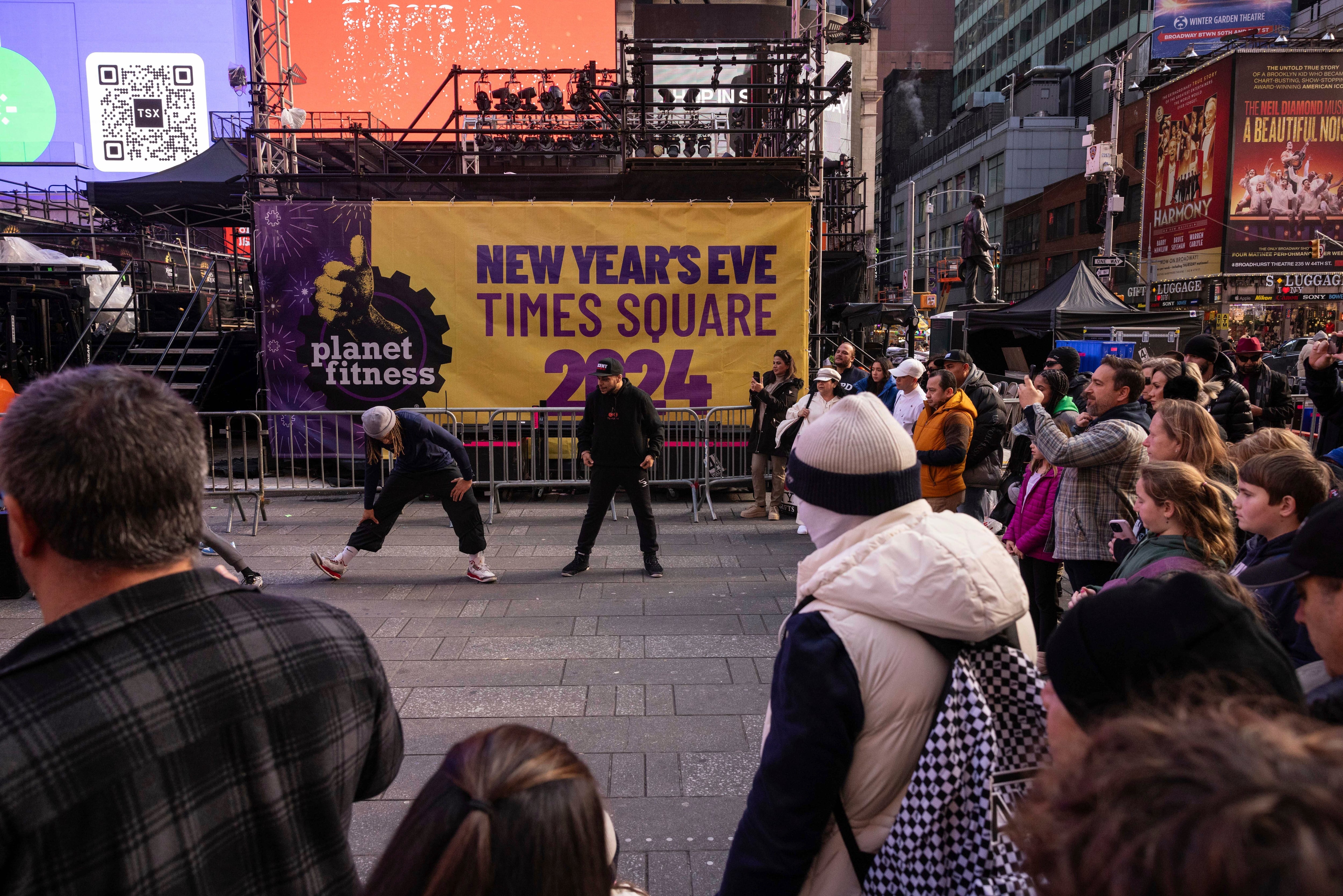 Turistas pasan junto a un cartel de Fin de Año antes de la celebración en Times Square, Nueva York, el 29 de diciembre de 2023. (AP Foto/Yuki Iwamura)