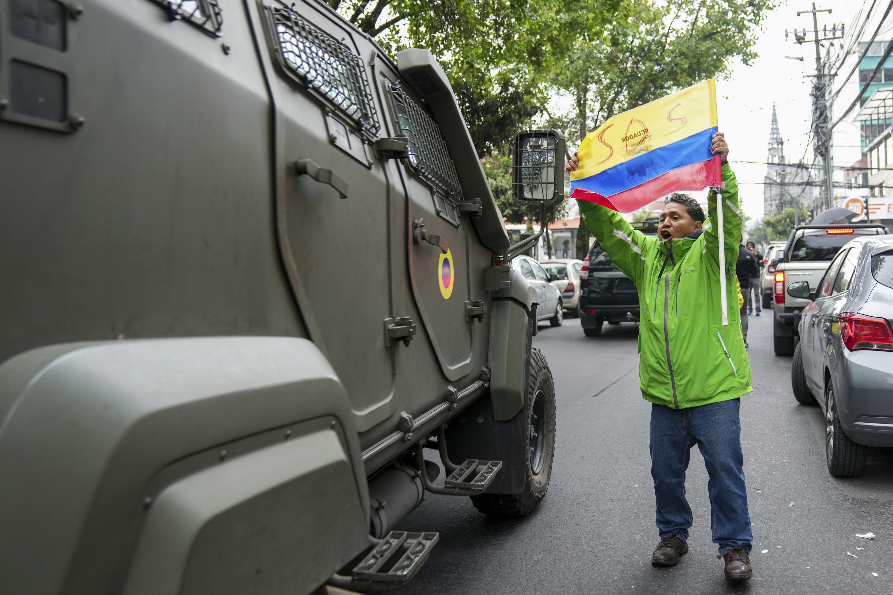 Un partidario del exvicepresidente ecuatoriano Jorge Glas protesta mientras un vehículo militar lo transporta desde el centro de detención en el que estuvo detenido tras su arresto en la embajada de México en Quito, Ecuado. (Foto AP/Dolores Ochoa)