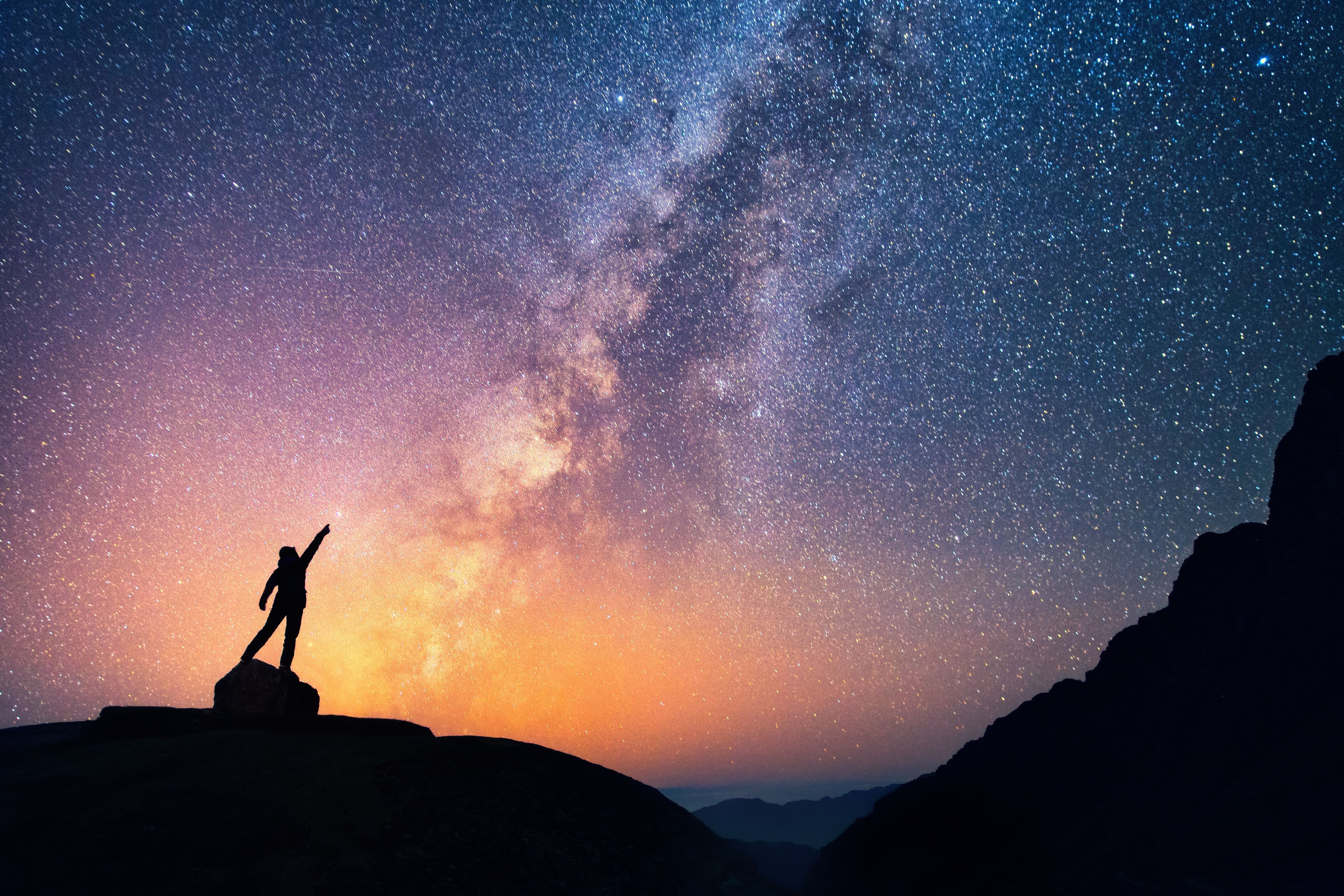 Una persona, de pie, apunta una estrella brillante en la Vía Láctea. Los seres humanos deben repensar su relación con la naturaleza en este tiempo