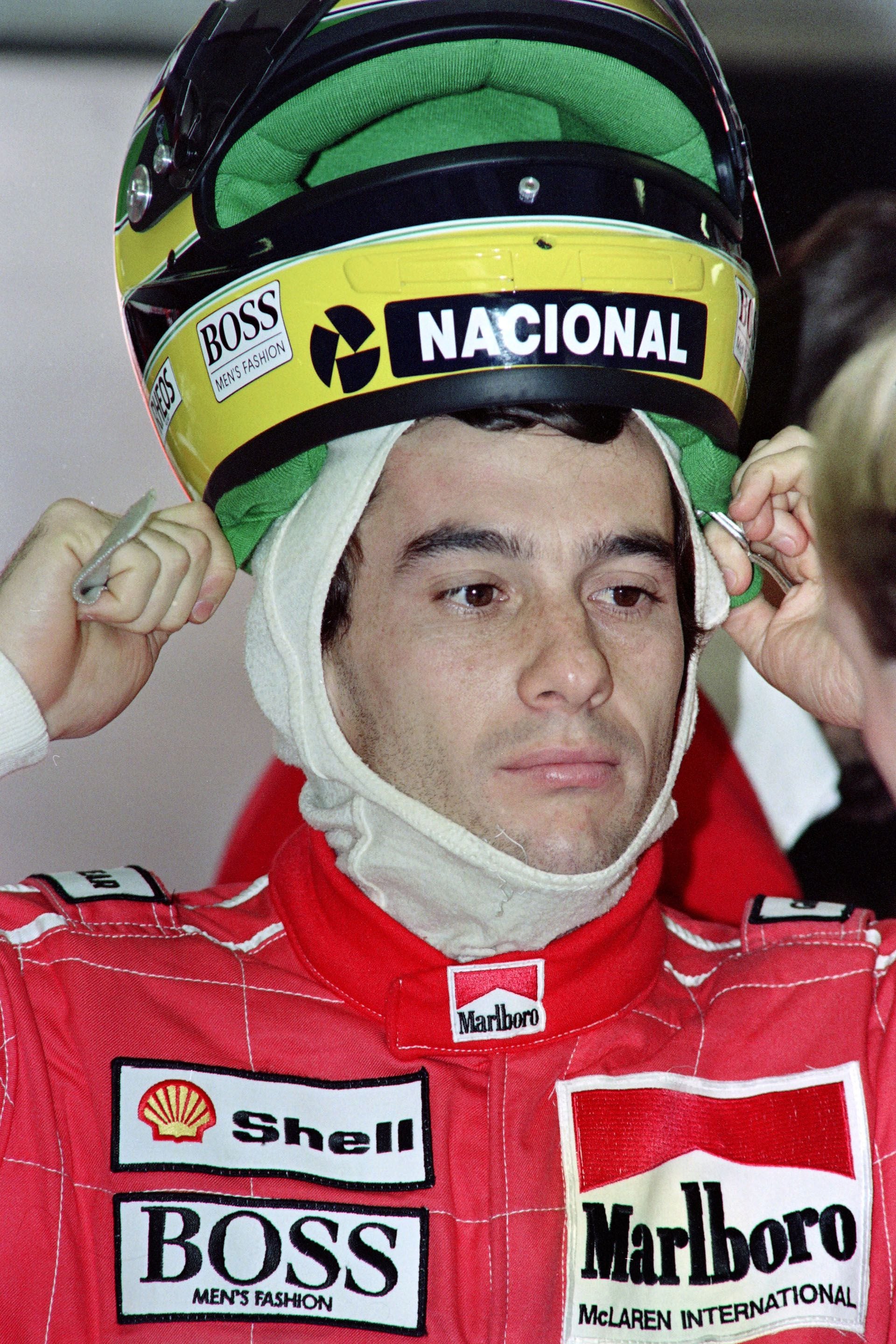 Ayrton Senna en el Gran Premio de Hungría, en agosto de 1990, colocándose su clásico casco, con los colores de Brasil (AFP)