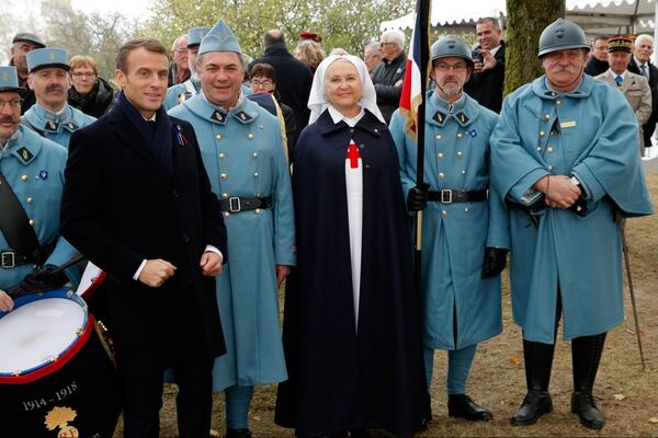 El presidente francés Emmanuel Macron posa junto a recreacionistas vestidos como soldados y enfermeras en Morhange, en el este del país (AFP)