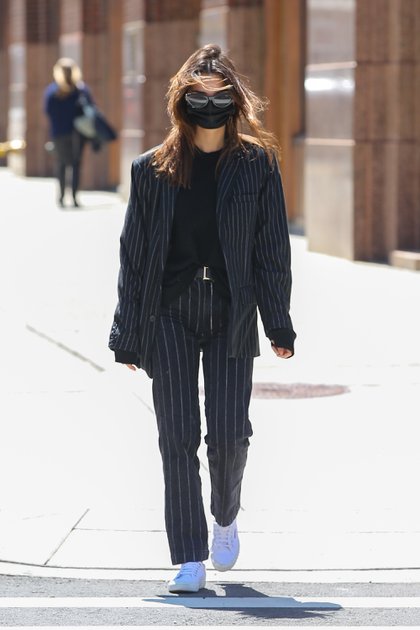 Emily Ratajkowski dio un paseo por las calles de Nueva York. La modelo lució un conjunto de pantalón y saco negro con rayas blancas que combinó con una remera negra, lentes de sol y tapabocas del mismo color. Completó su outfit con zapatillas blancas