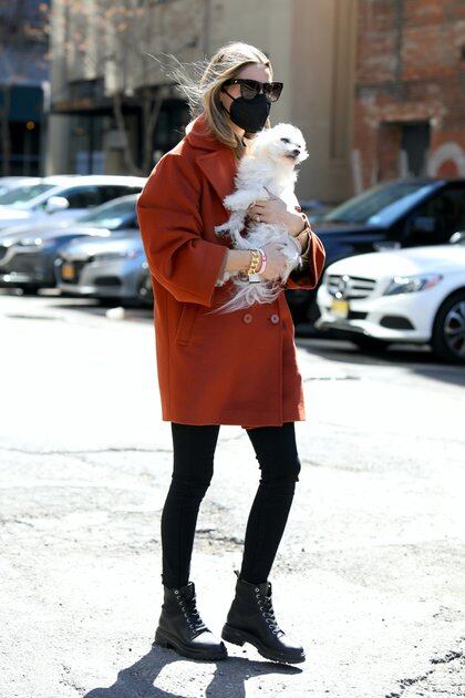 Olivia Palermo llevó a pasear a su perro, Mr. Butler, a un parque de Nueva York. Llevó al bichón maltés en brazos y vistió un pantalón negro, borcegos y tapado rojo