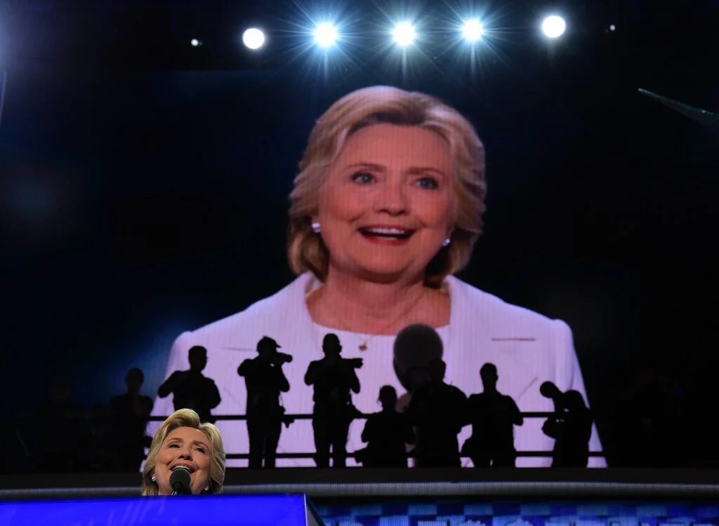 Los fotógrafos y la pantalla gigante sobre Hillary (AFP)