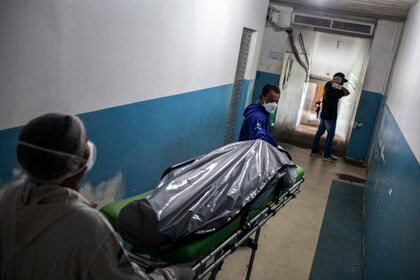Profesionales de la salud cargan el cuerpo de una persona víctima de COVID-19 en el Hospital General de Manacapuru, el 8 de junio de 2020, en Manacapuru, Amazonas (Brasil). EFE/Raphael Alves
