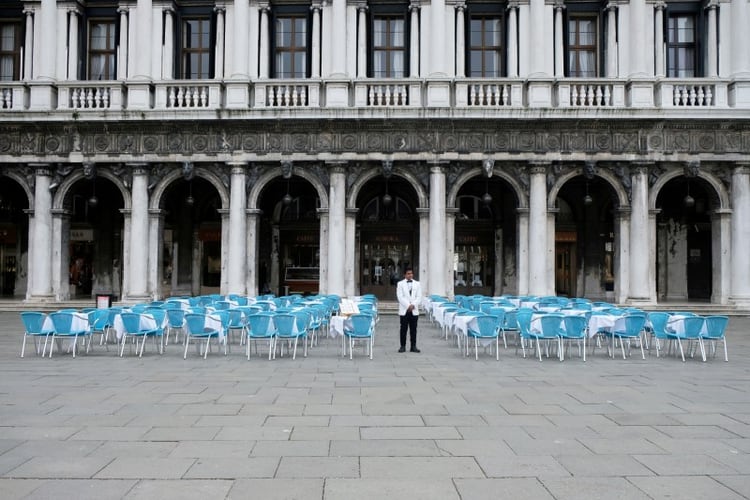 FOTO DE ARCHIVO: Un camarero al lado de mesas vacías fuera de un restaurante en la Plaza de San Marcos, que suele estar llena de turistas, después de que el gobierno italiano adoptara un decreto con nuevas medidas de emergencia para contener el coronavirus, en Venecia, Italia, 5 de marzo, 2020. REUTERS/Manuel Silvestri/Foto de Archivo